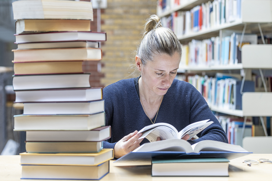 Bibliothek, Frau liest Bücher in der Bibliothek